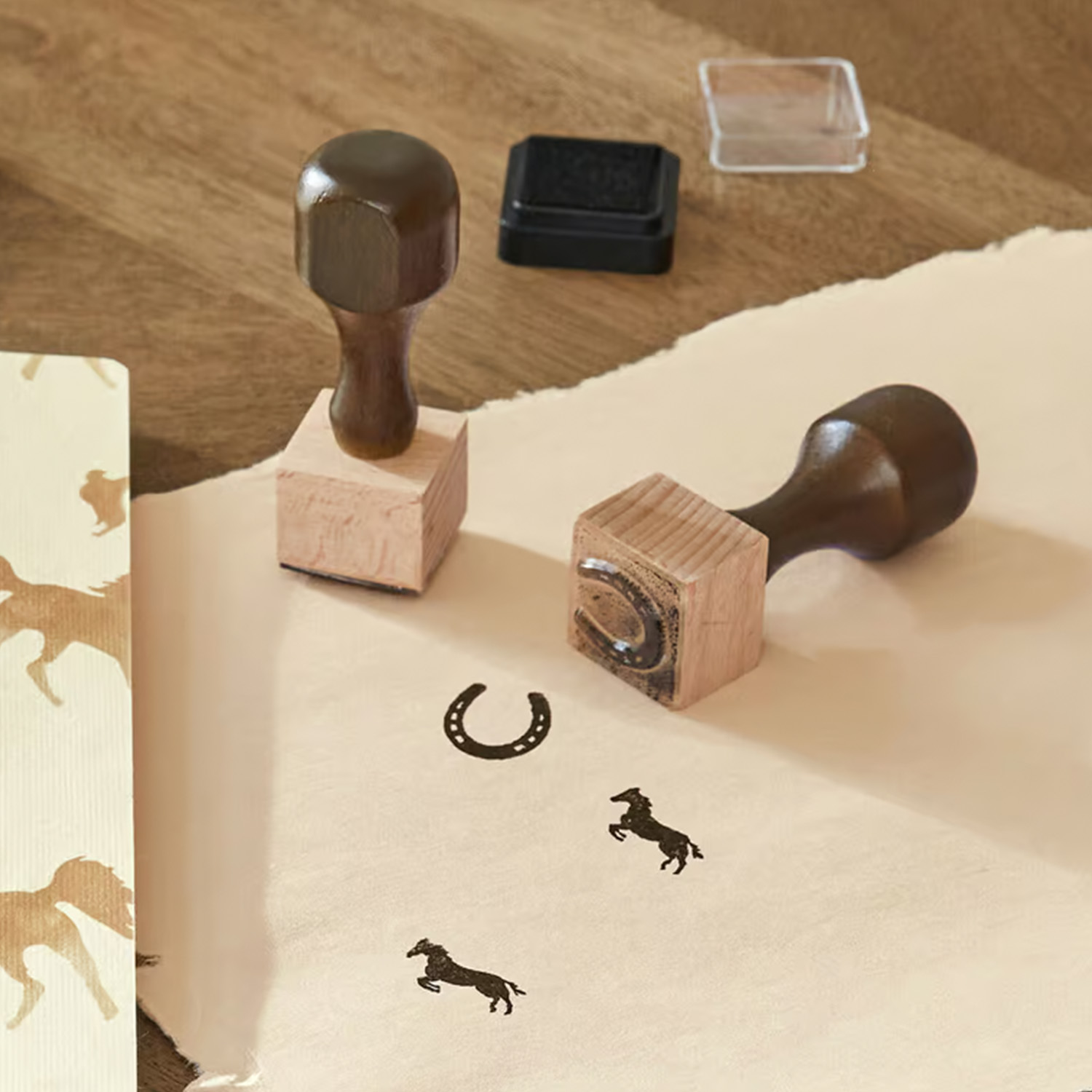 Holzstempel mit Pferde- und Hufeisenmotiv auf beigem Papier zum Dekorieren