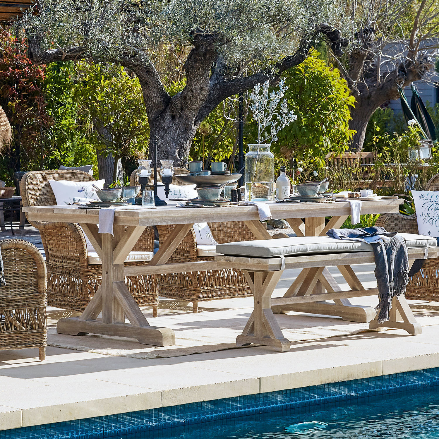 Tisch FSC®-100% Graslin Heller Holzesstisch mit Rattanstühlen am Pool in natürlicher Gartenumgebung für den Aussenessbereich
