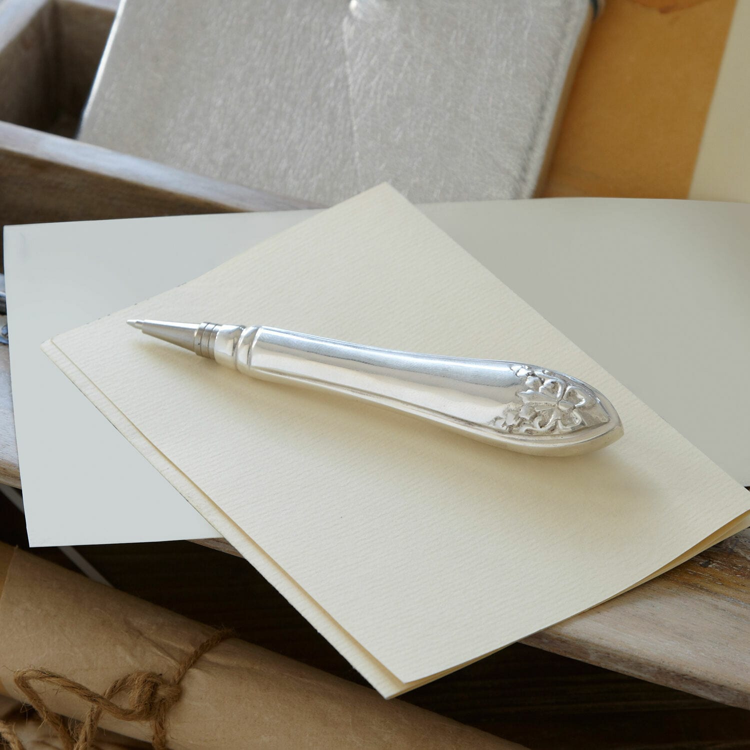 Kugelschreiber Barry Eleganter silberner Kugelschreiber mit dekorativem Muster am Griff auf cremefarbenem Papier
