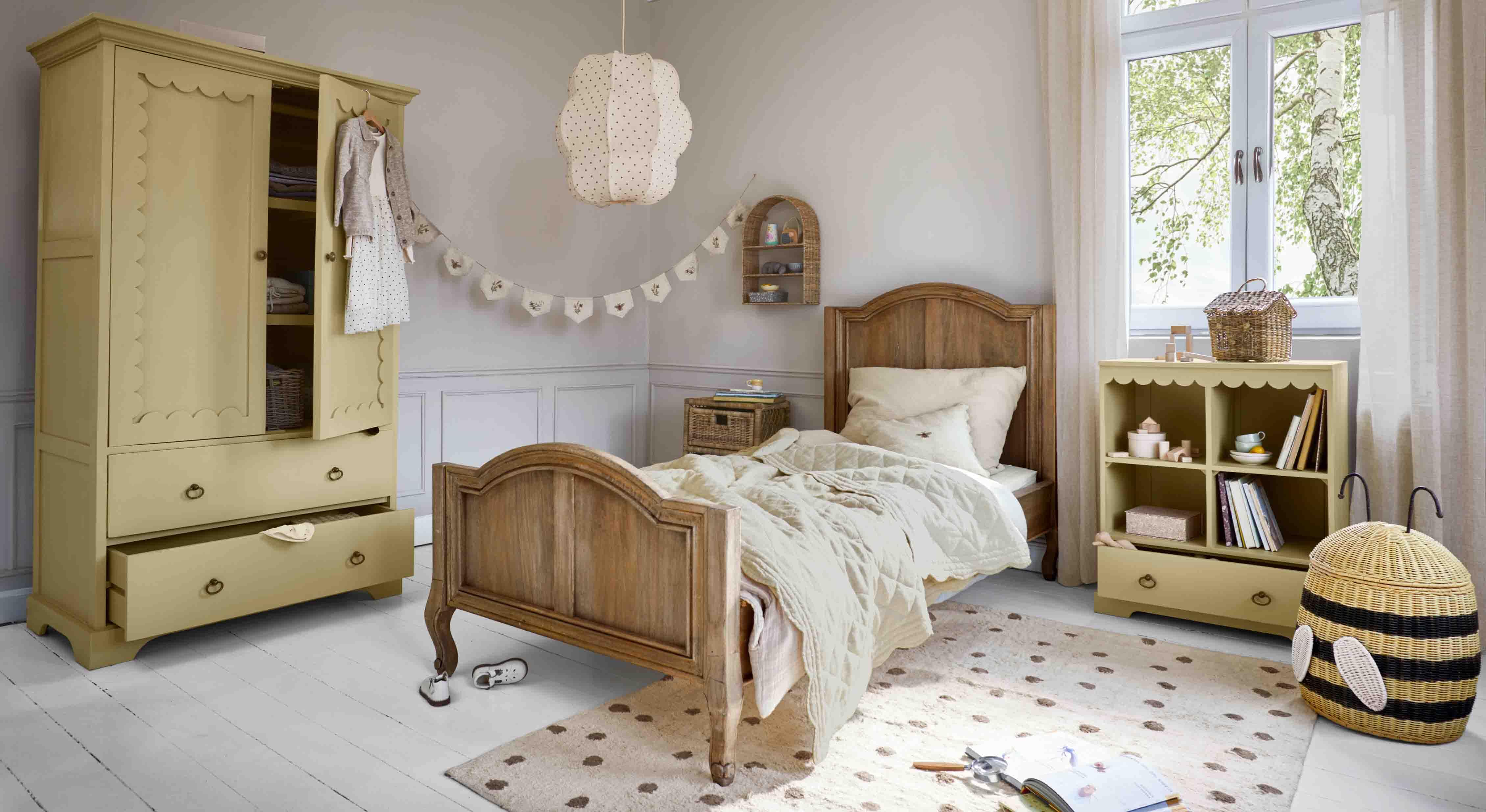 Gemütliches Kinderzimmer mit Holzbett, gelbem Schrank und Regal aus Holz und Korb aus Weide