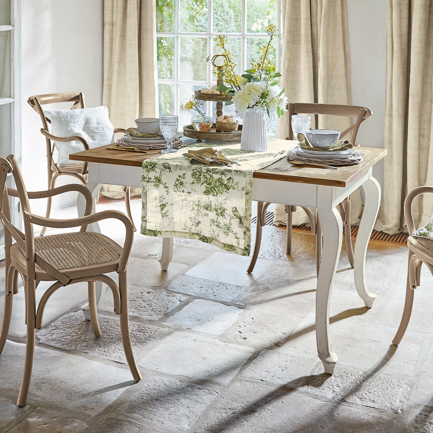 Tisch Plaish Esszimmer mit weissem Holztisch und beigen Rattanstühlen im natürlichen Landhausstil
