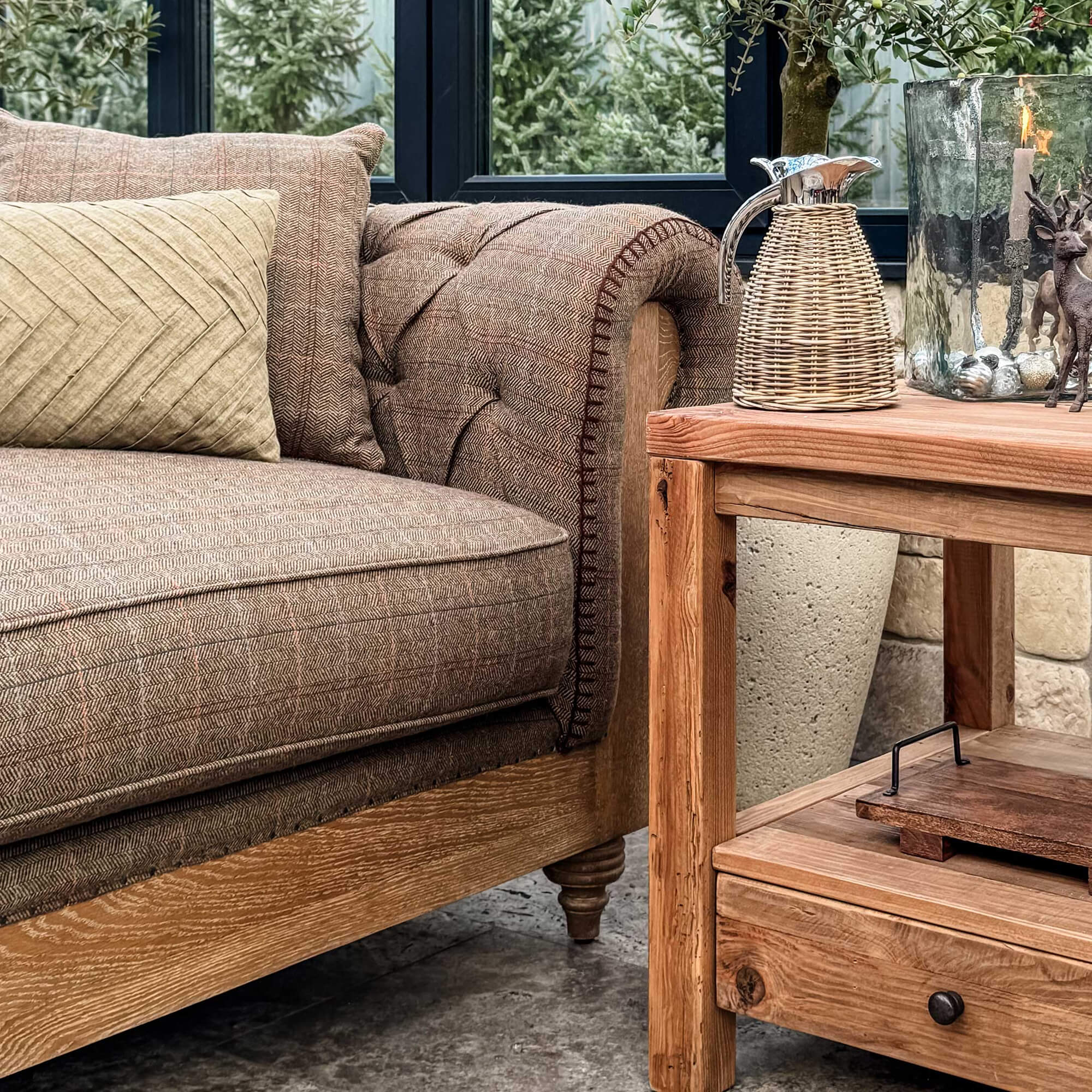 Braunes Stoffsofa mit Holzrahmen neben einem Holztisch mit weihnachtlicher Dekoration.