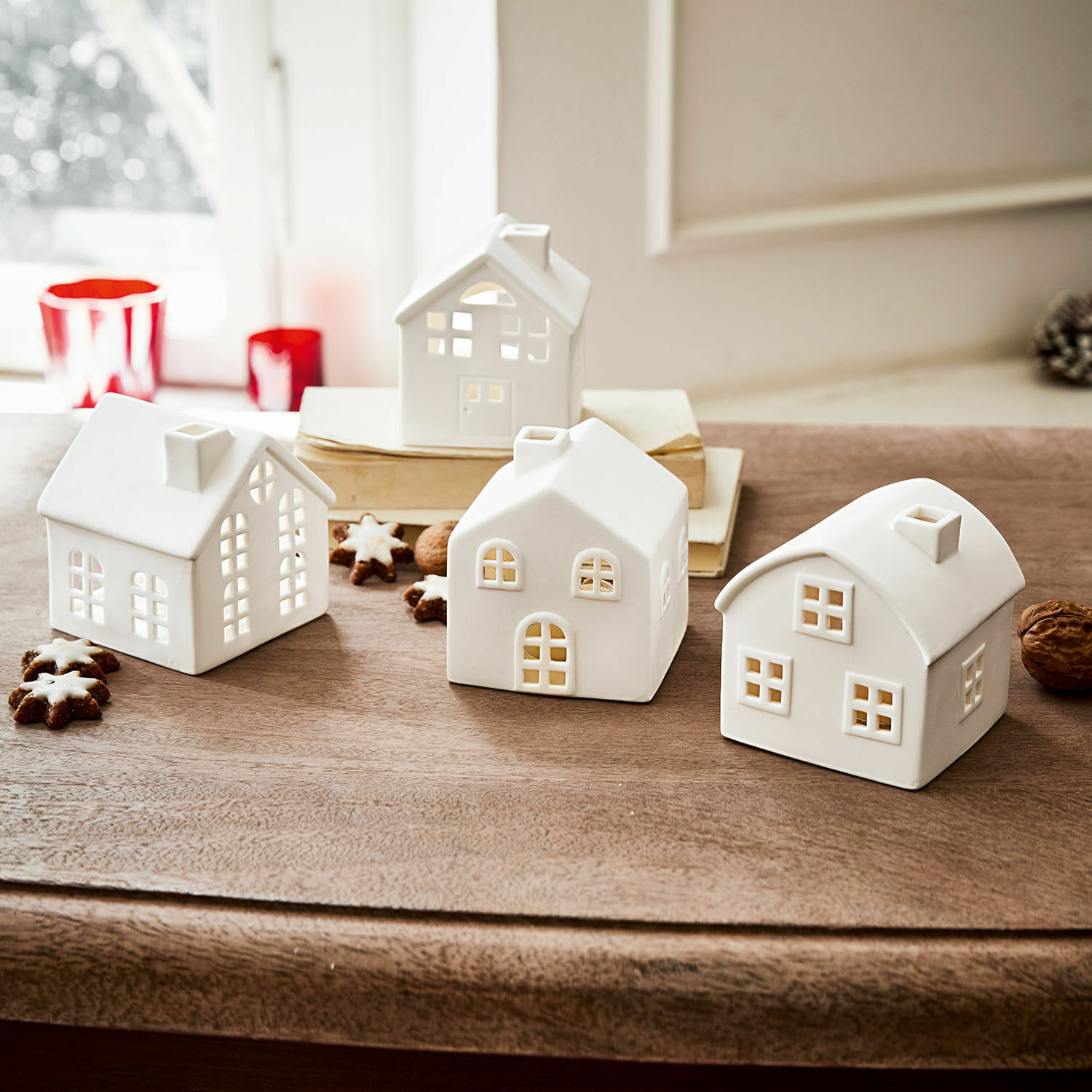 Windlicht 4er Set Country Weisse Keramikhäuser mit Fensteröffnungen für Kerzenlicht auf Holztisch, weihnachtliche Dekoration
