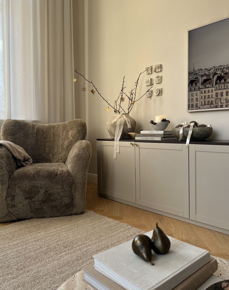Gemütliche Winterecke mit weichem Sessel und natürlichen Dekorationen auf hellem Sideboard