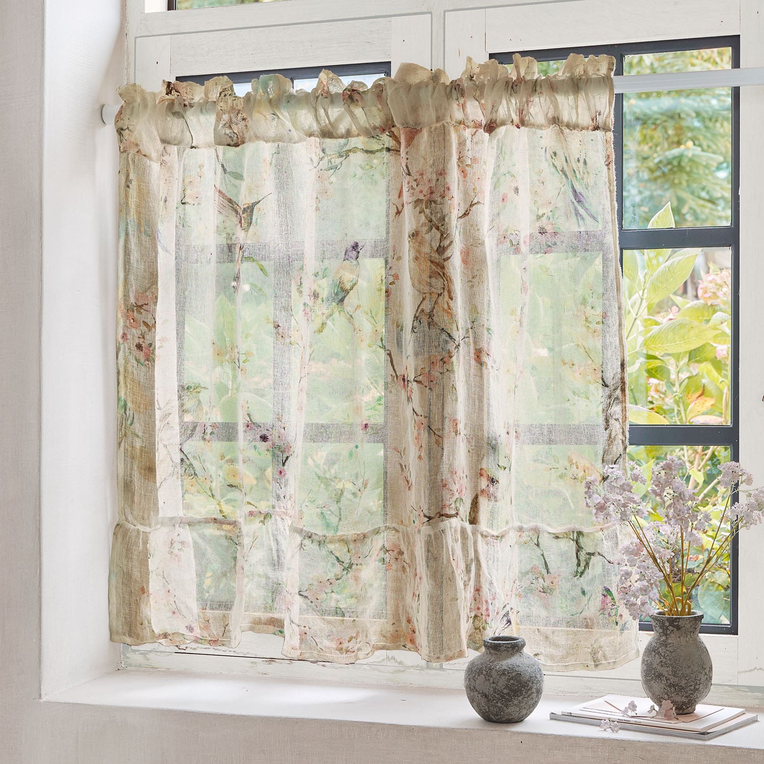 Transparenter Vorhang aus leichtem beigem Stoff mit Blumen- und Vogelmuster am Fenster