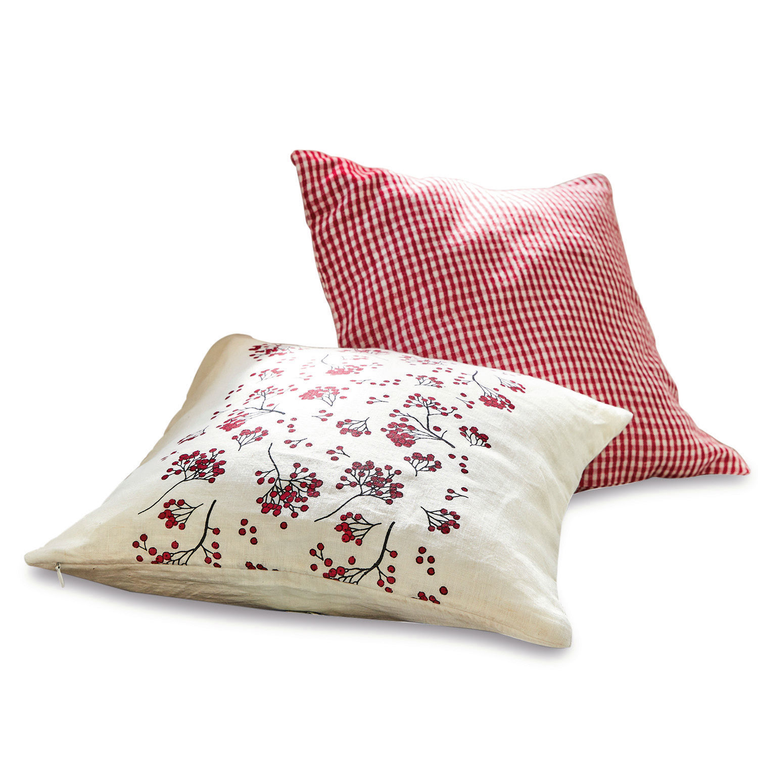 Zwei dekorative Leinenkissen, eines rot-weiss kariert, das andere mit rotem Beerendruck