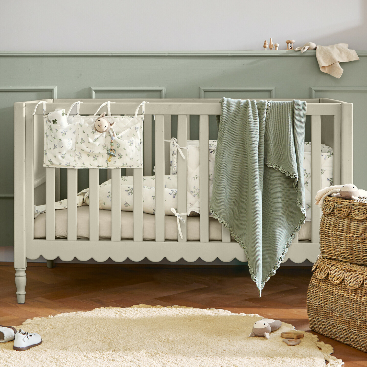 Babybett Leily Beiges Kinderbett aus Holz mit grüner Decke und floralem Bettzeug in gemütlichem Kinderzimmer