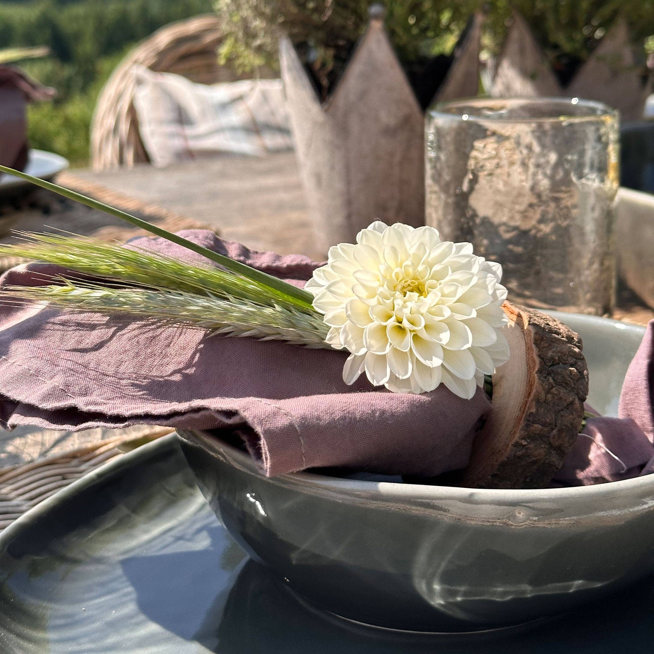 Weisse Blumendekoration auf rosa Leinenserviette mit rustikalem Holzring