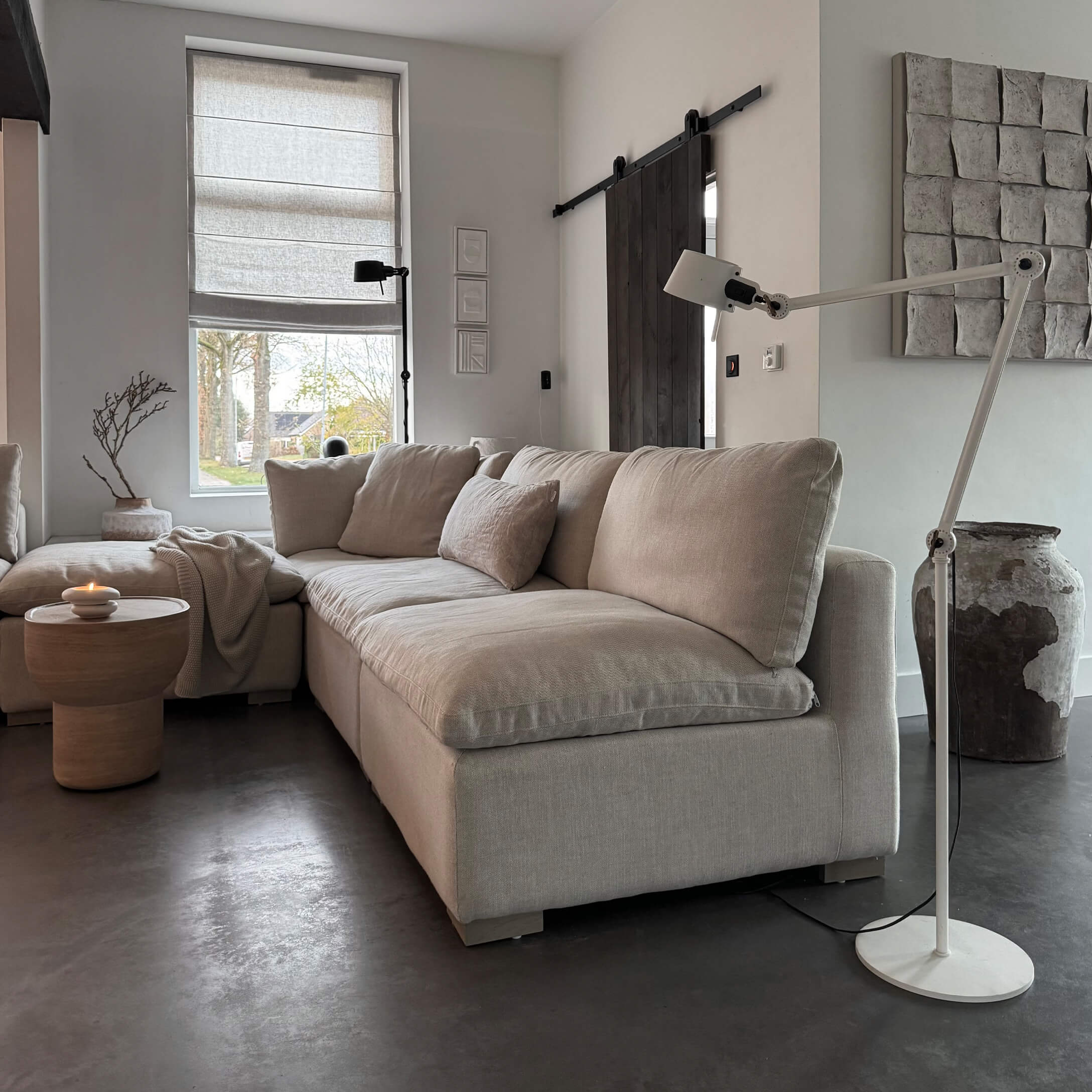 Beige Ecksofa aus Stoff in modernem Wohnzimmer mit Stehleuchte und Holzbeistelltisch