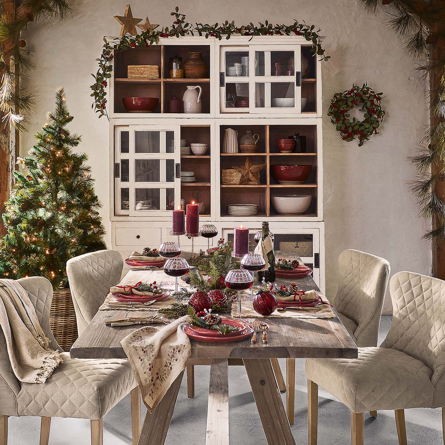 Rustikaler Holztisch mit beigen, gesteppte Stühlen und festlicher Weihnachtsdekoration im Esszimmer