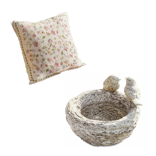 Dekoratives Kissen mit Blumenmuster und steinerne Schale mit Vögeln im Shabby-Chic-Stil