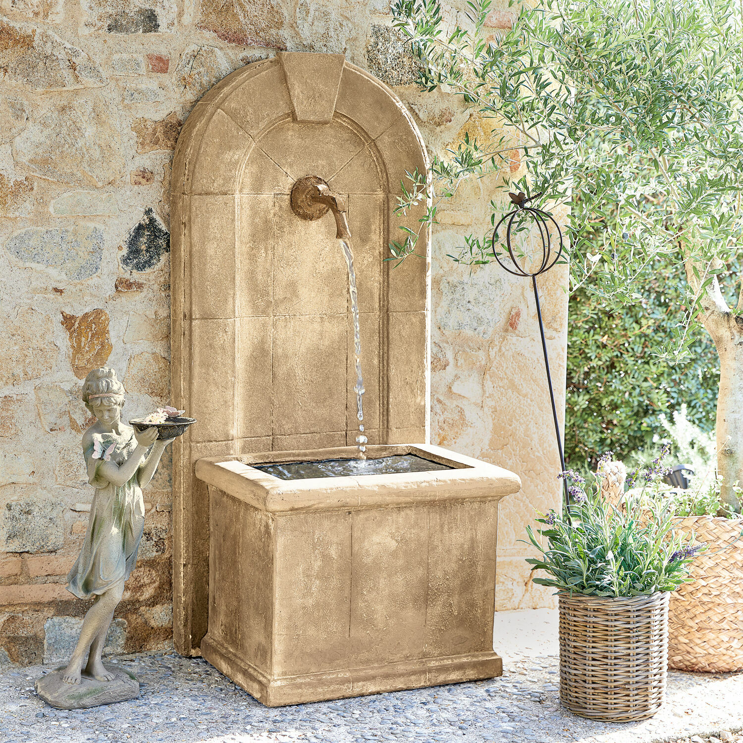 Brunnen Ginette Dekorativer Gartenbrunnen aus beigem Stein mit Wasser und Mädchenfigur vor Steinmauer