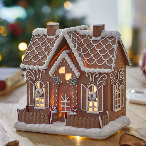 Dekoratives Lebkuchenhaus mit weisser Zuckerglasur und Beleuchtung, ideal für Weihnachtsdekoration