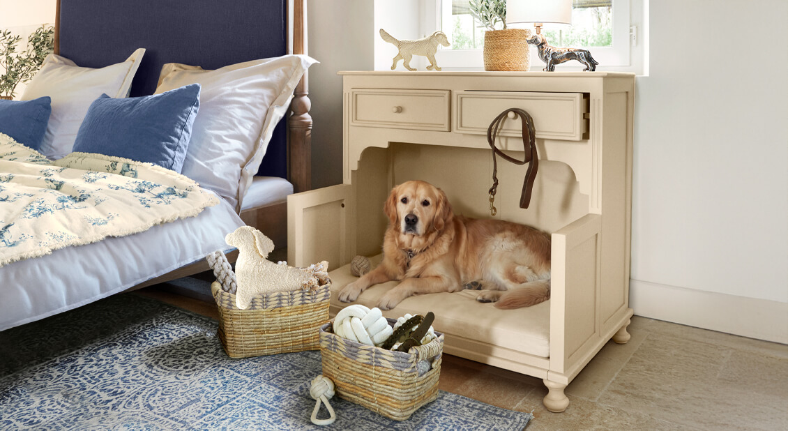 Beiger Holzschrank mit Hundebett und Polster, neben Bett mit blauen Kissen im Schlafzimmer