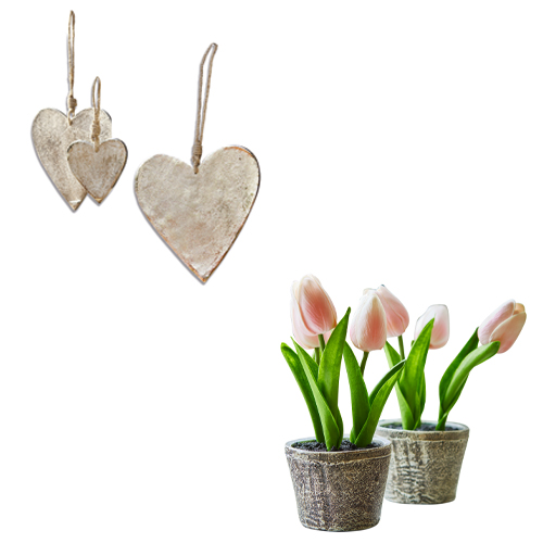 Dekorative silberne Metallherzen und künstliche Tulpen in Töpfen als Frühlingsdekoration