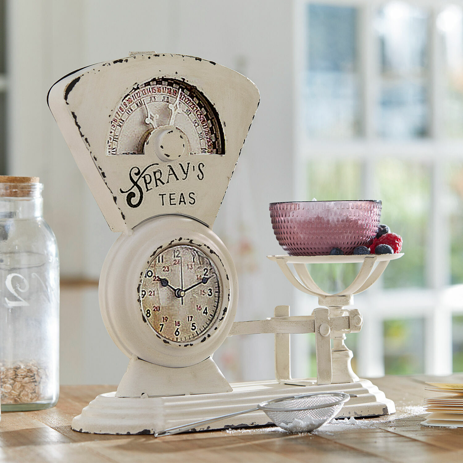 Uhr Balances Weisse Vintage-Küchenwaage aus Metall mit rosa Schale und frischen Beeren auf Holztisch