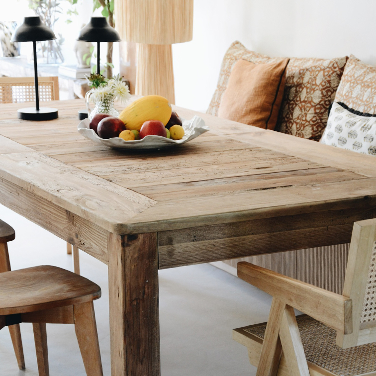 Rustikaler Holzesstisch mit Obstschale und Tischlampen in hellem Wohnraum