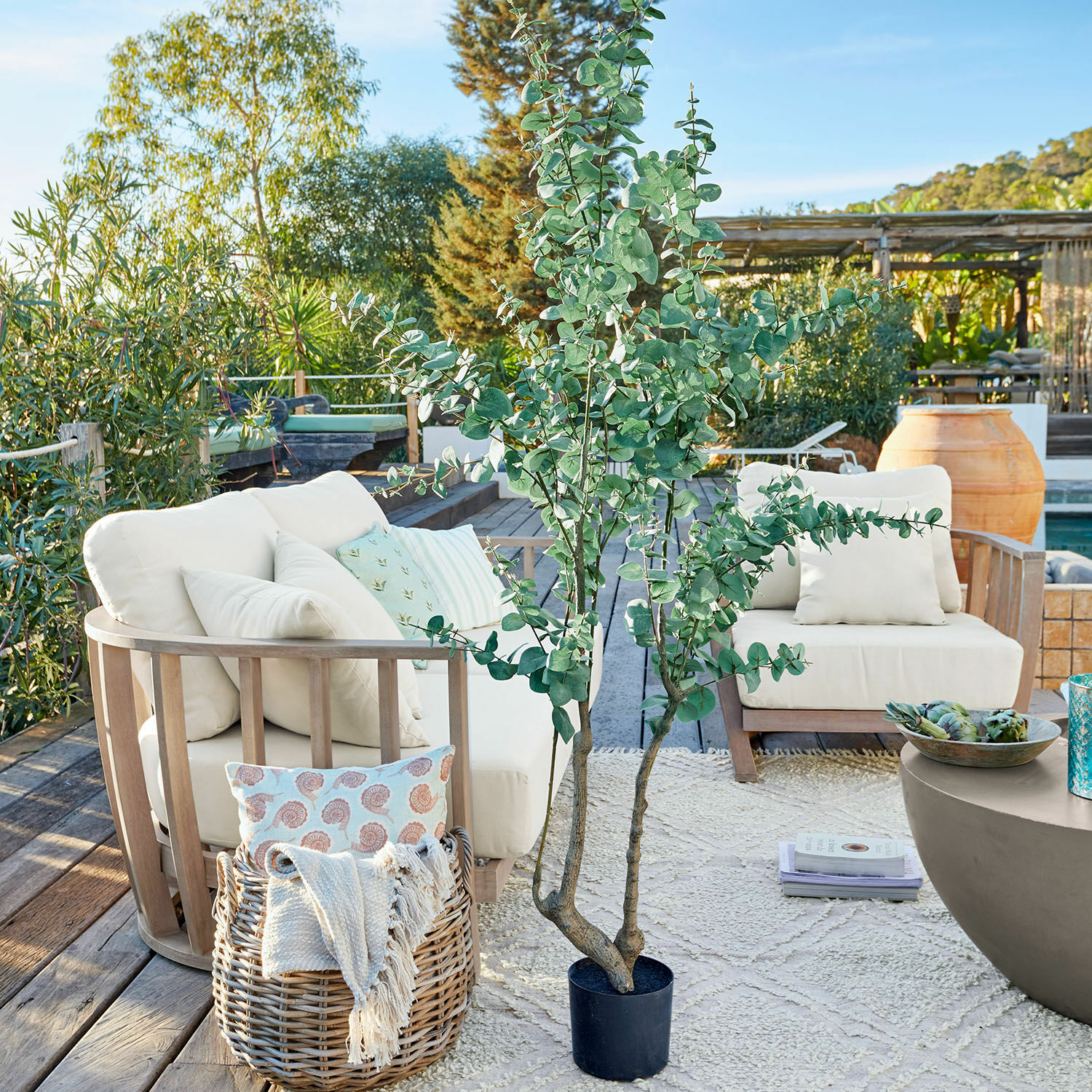 Deko-Topfpflanze Dorevi Grosser künstlicher Eukalyptus in schwarzem Topf auf Terrasse mit Gartenmöbeln und Dekorationen