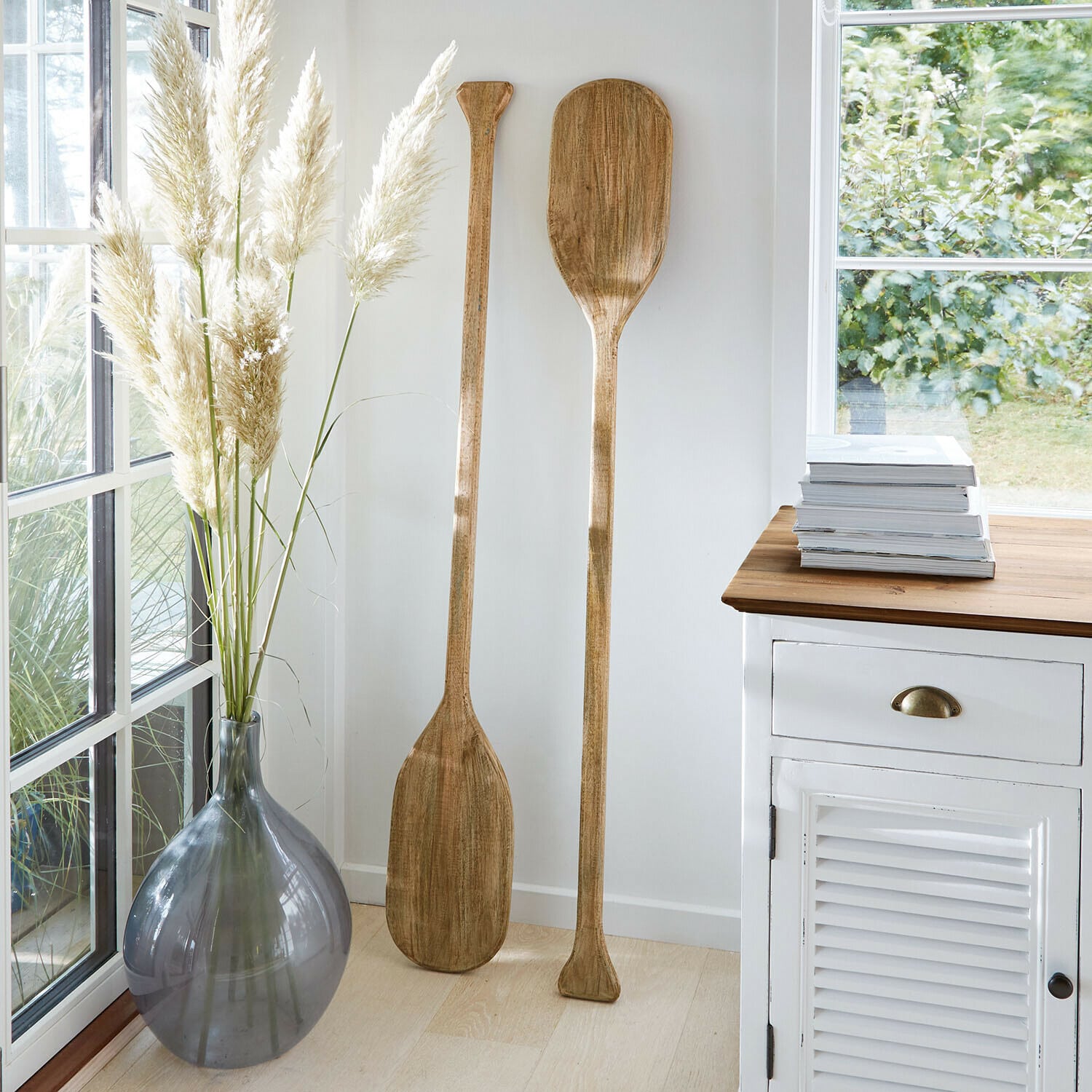 Deko-Paddel 2er Set Windermount Zwei dekorative Holzpaddel in hellem Raum neben grauer Vase und weissem Schrank