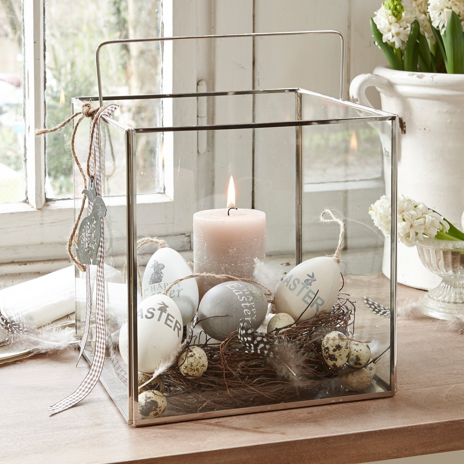 Windlicht Otero Glaslaterne mit Metallrahmen, dekoriert mit Ostereiern und Kerze auf Holztisch