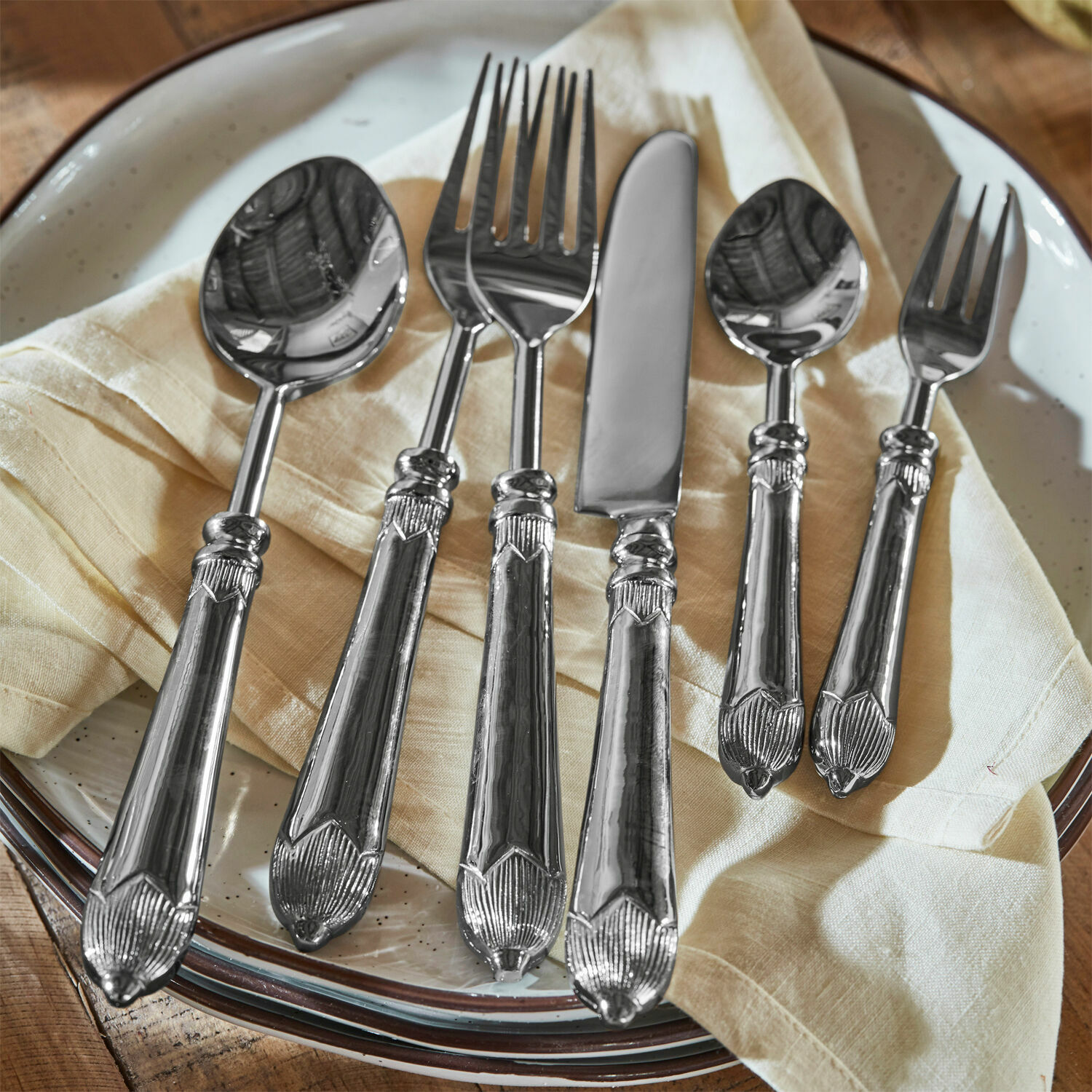 Besteck Gasharba Set silberner Bestecke aus Edelstahl auf cremefarbener Serviette auf Teller, elegante Küchenaccessoires