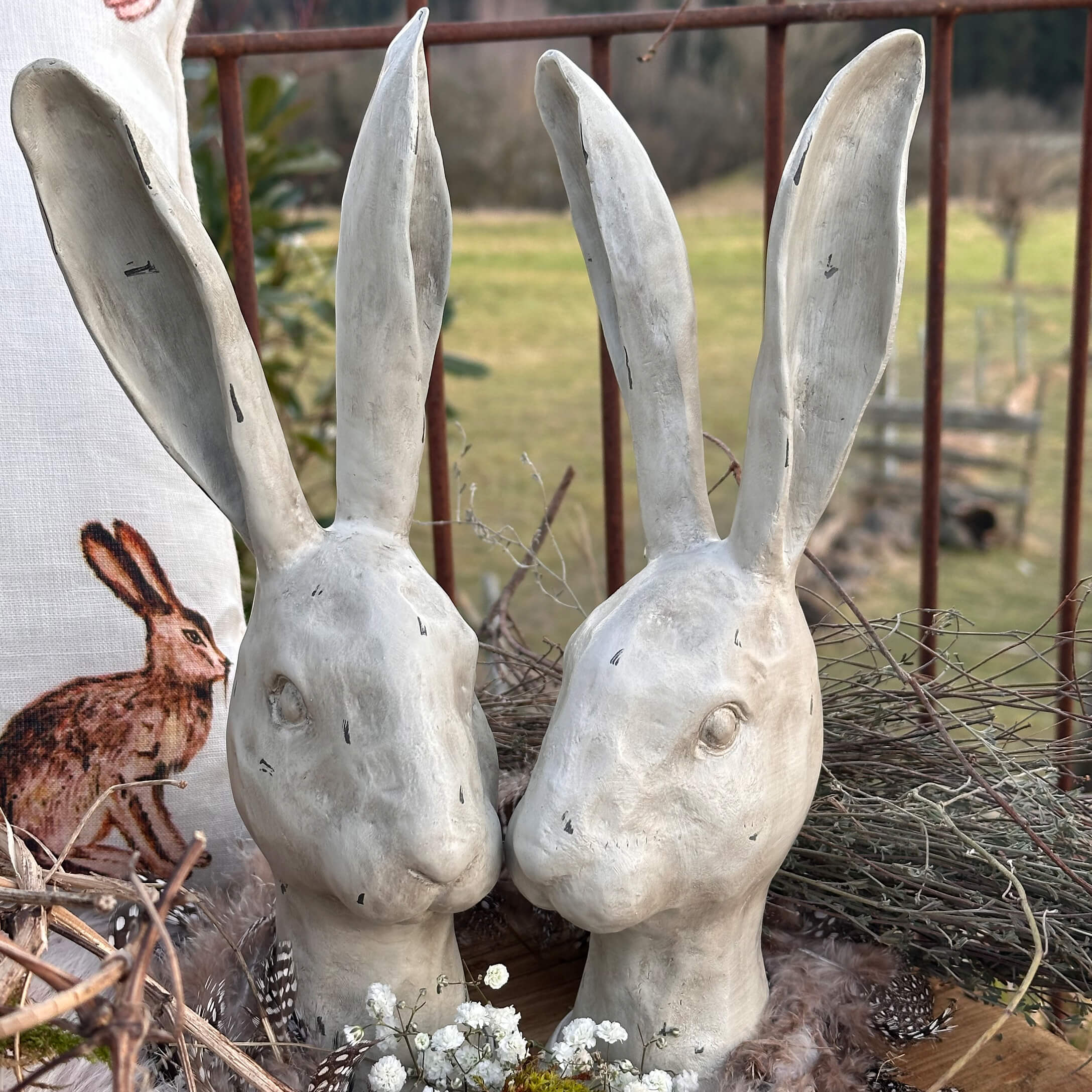 Weisse Keramik-Hasenköpfe mit langen Ohren als rustikale Osterdekoration im Landhausstil