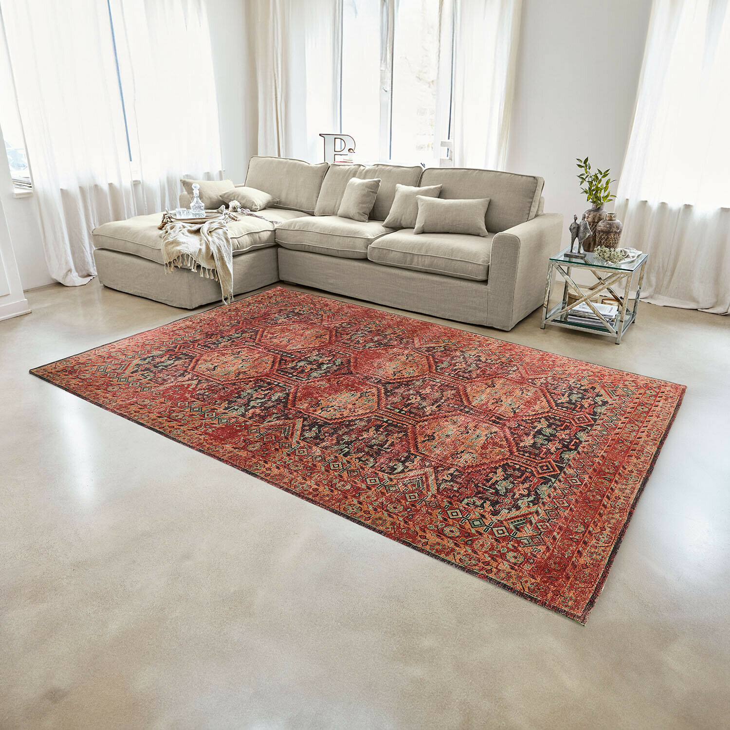 Roter Teppich mit geometrischem Muster im modernen Wohnzimmer mit beigem Sofa und Glastisch