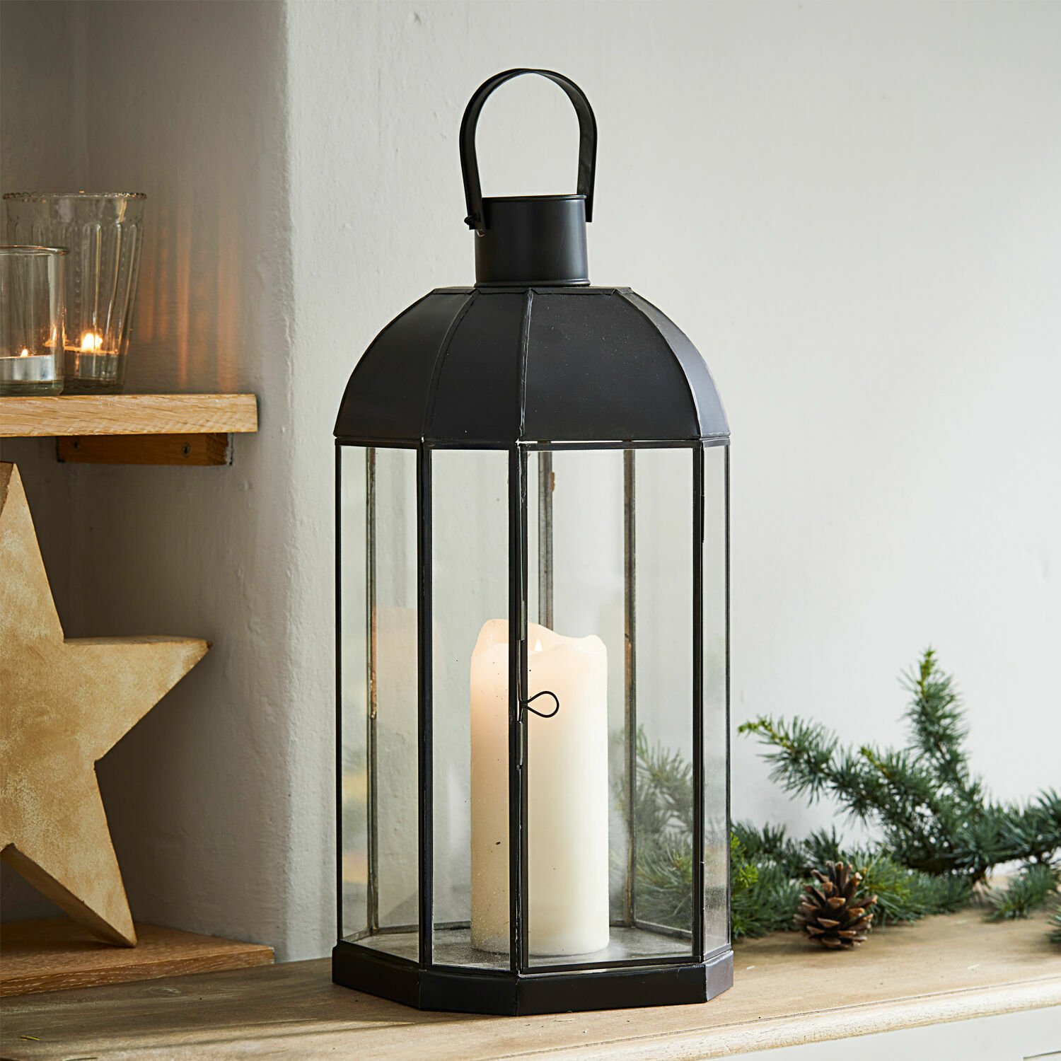 Laterne Comines Schwarze Metalllaterne mit klarem Glas und weisser Kerze auf Holztisch mit Weihnachtsdekoration
