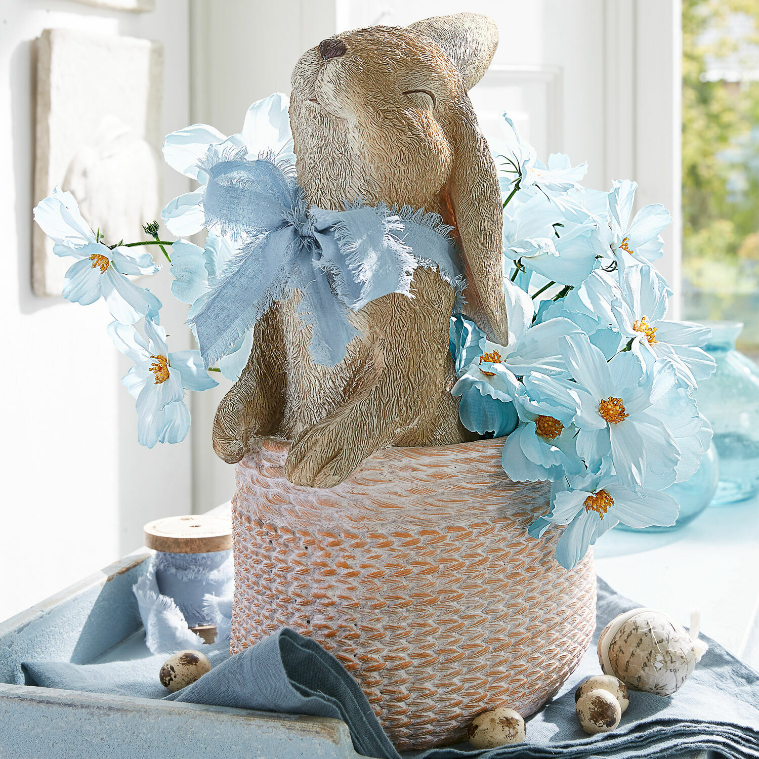 Übertopf Merisette Dekorativer Hase aus Material im Korb mit blauen Blumen und Schleife für Frühlingsdekoration