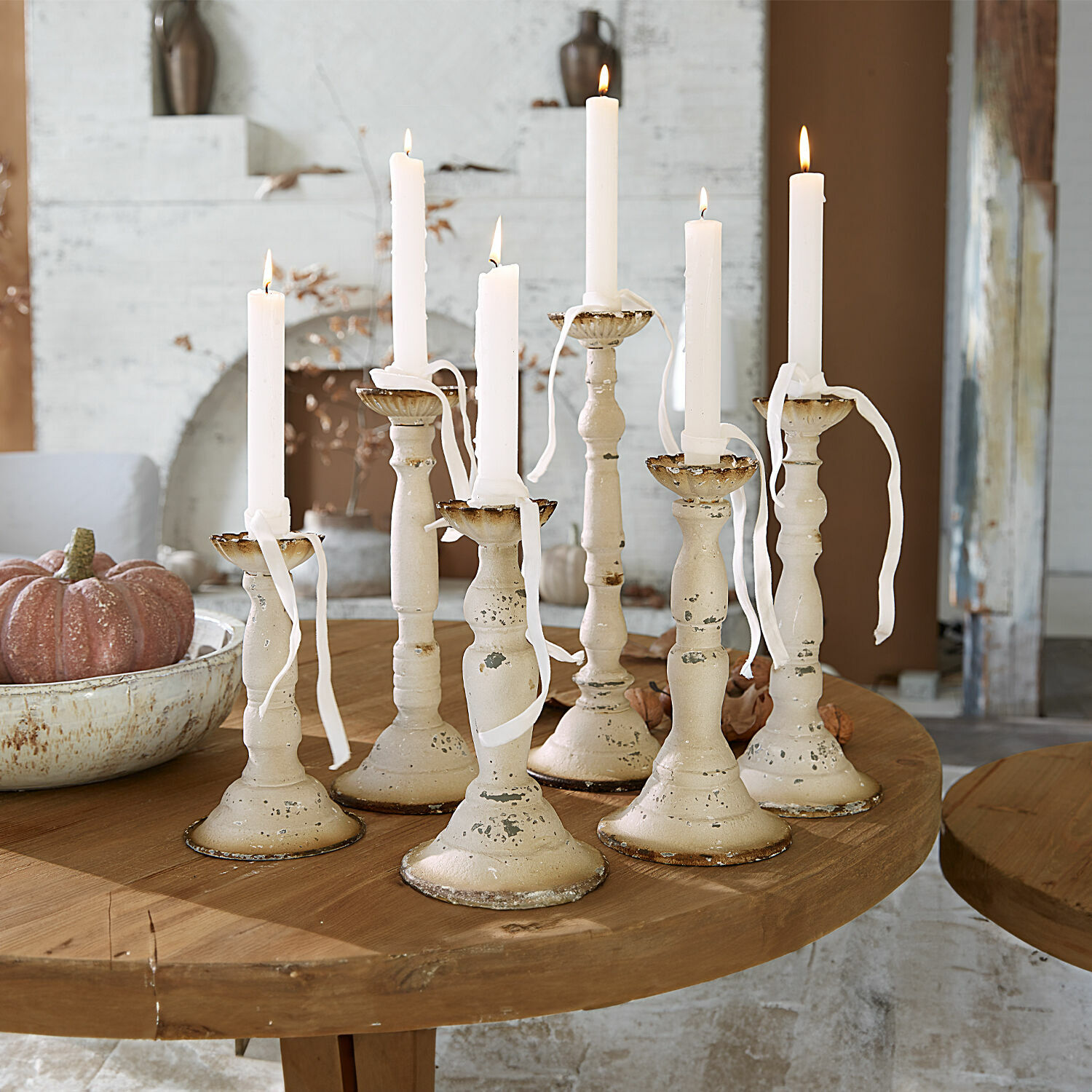 Kerzenhalter 6er Set Rivondelle Set aus sieben cremefarbenen Metallkerzenhaltern mit weissen Kerzen auf Holztisch, Wohnraumdekoration