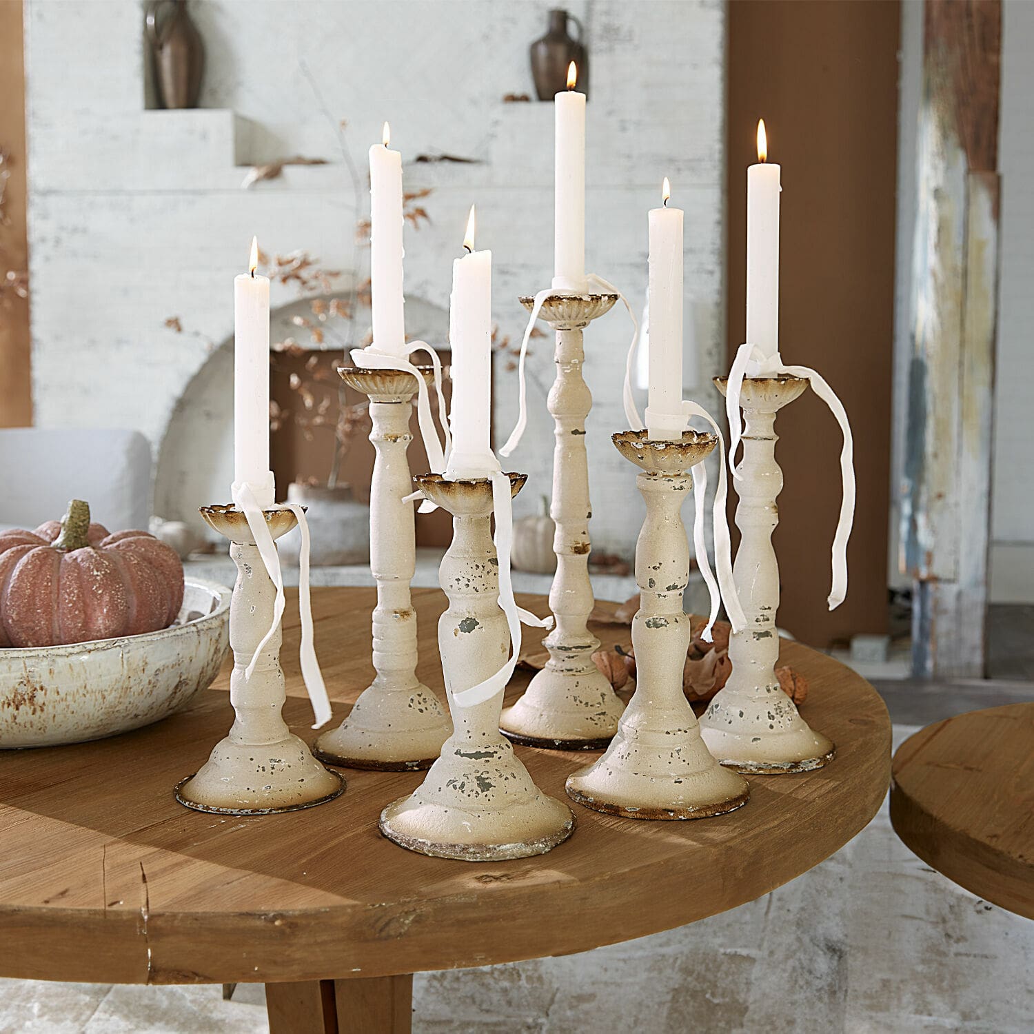 Kerzenhalter 6er Set Rivondelle Set aus sieben cremefarbenen Metallkerzenhaltern mit weissen Kerzen auf Holztisch, Wohnraumdekoration