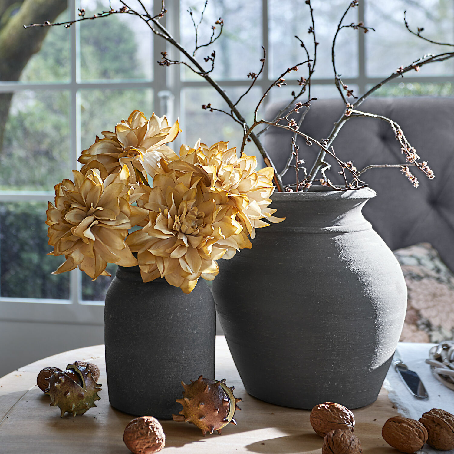 Vase 2er Set Molduc Zwei graue Keramikvasen mit getrockneten Blumen und Zweigen auf einem Holztisch mit Wallnüssen