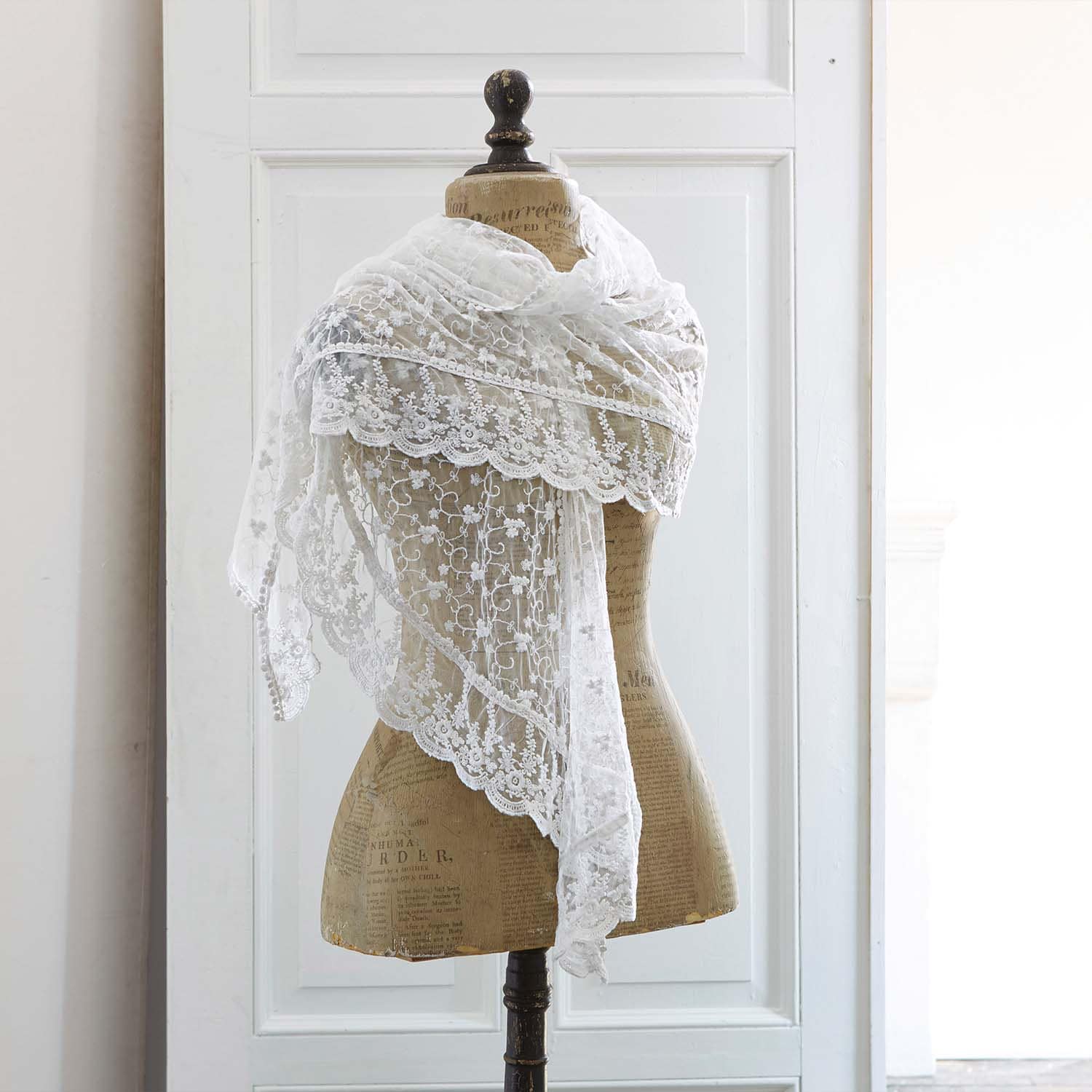 Feiner weisser Spitzen-Schal mit floralem Muster auf Schneiderpuppe, elegantes Modeaccessoire