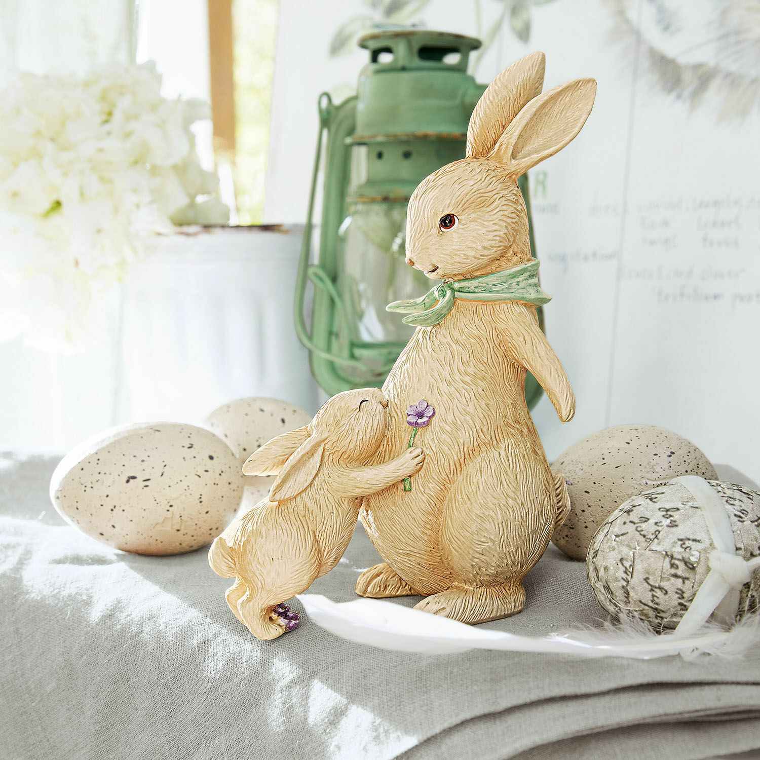 Deko-Hasen Susans Beige Hasenfiguren aus Harz auf einem dekorativen Tisch mit Ostereiern als Frühlingsdekoration
