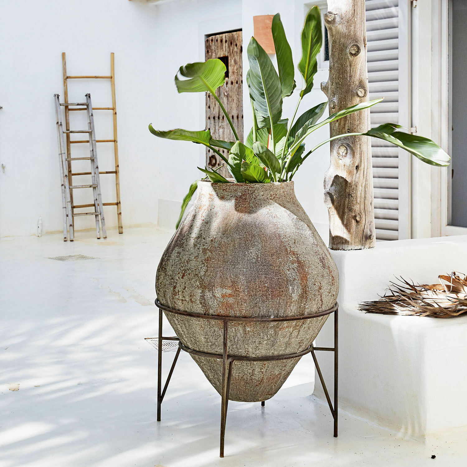 Vase Pive Grosser Steintopf auf Metallständer mit grüner Pflanze in hellem, minimalistischem Raum
