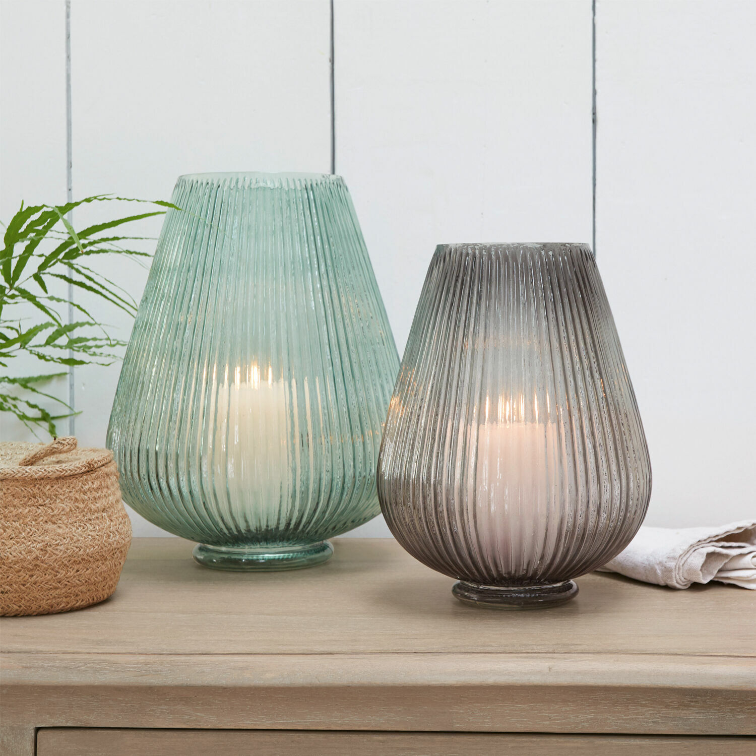 Vase 2er Set Fenis Zwei Glaslaternen in Grün und Grau mit weissen Kerzen auf hellem Holztisch
