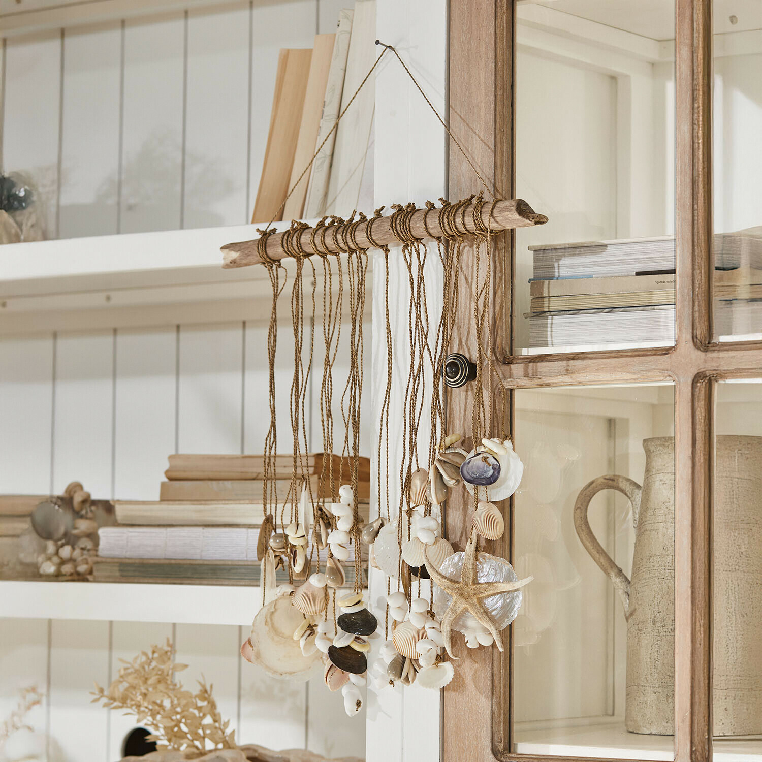 Hängendi Deko us Muschele und Seestärnli an Schnur mit Treibholz, natürlechi Farbe, maritime Wanddeko