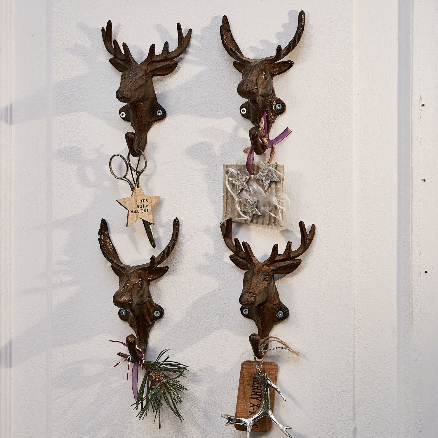 Haken 4er Set Deer Vier dekorative Wandhaken aus rostfarbenem Metall in Hirschkopf-Form mit weihnachtlichen Accessoires