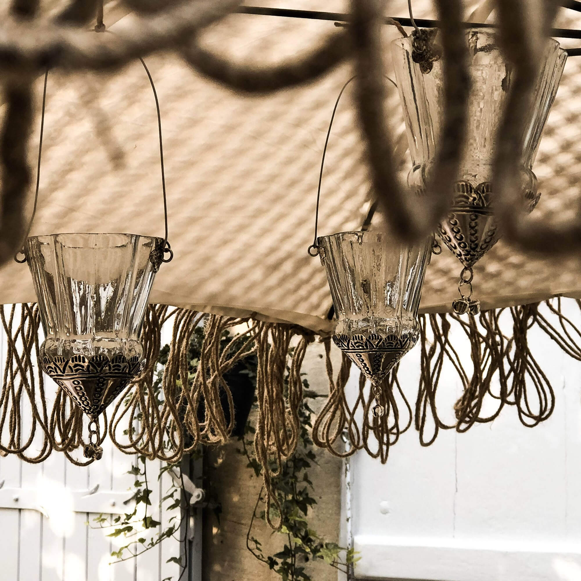 Glaslaternen mit Metallverzierung und Hängekordeln im Boho-Stil, dekorative Gartenbeleuchtung