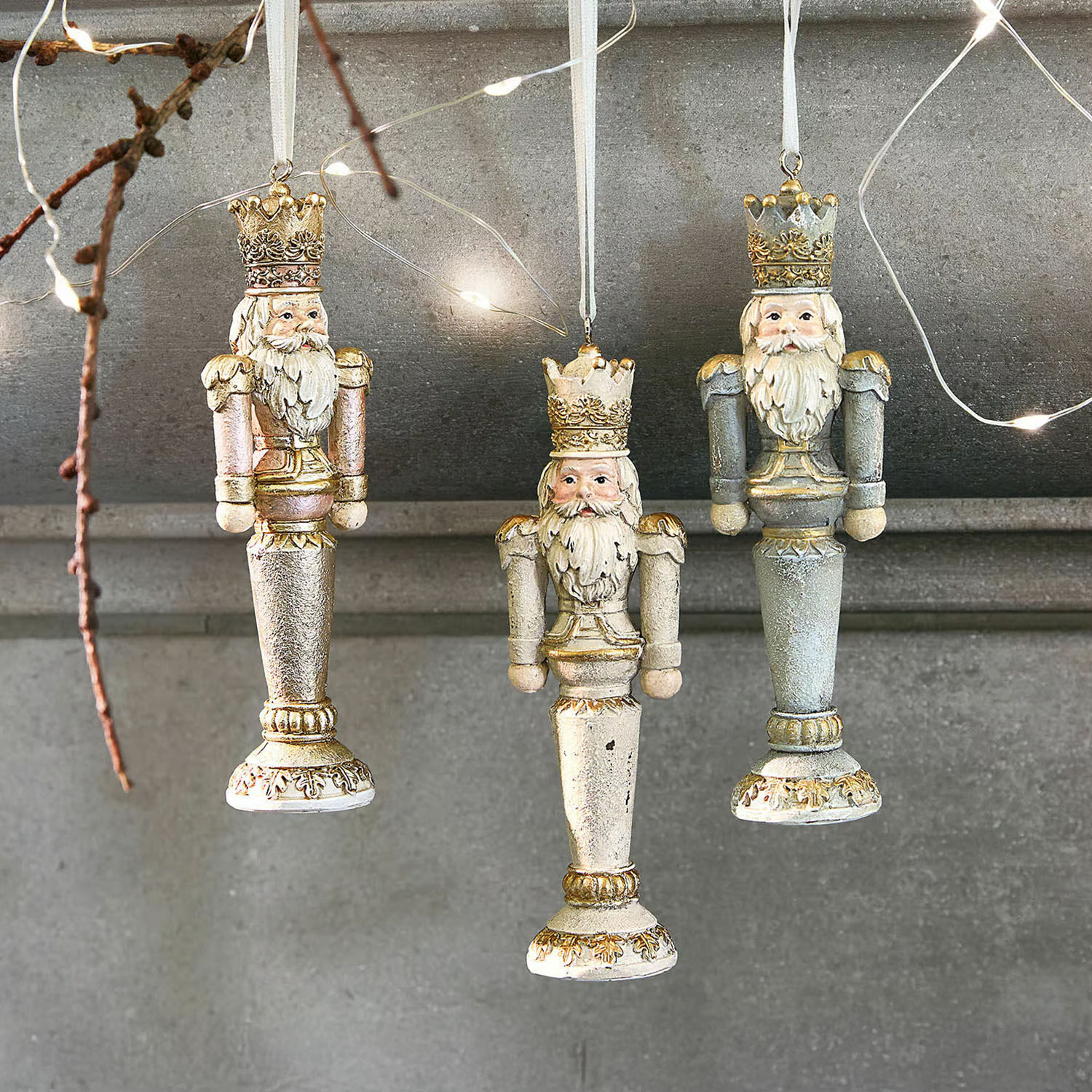 Drei hölzerne Weihnachtsanhänger in Form von Königen in Gold, Rosa und Blau zum Aufhängen
