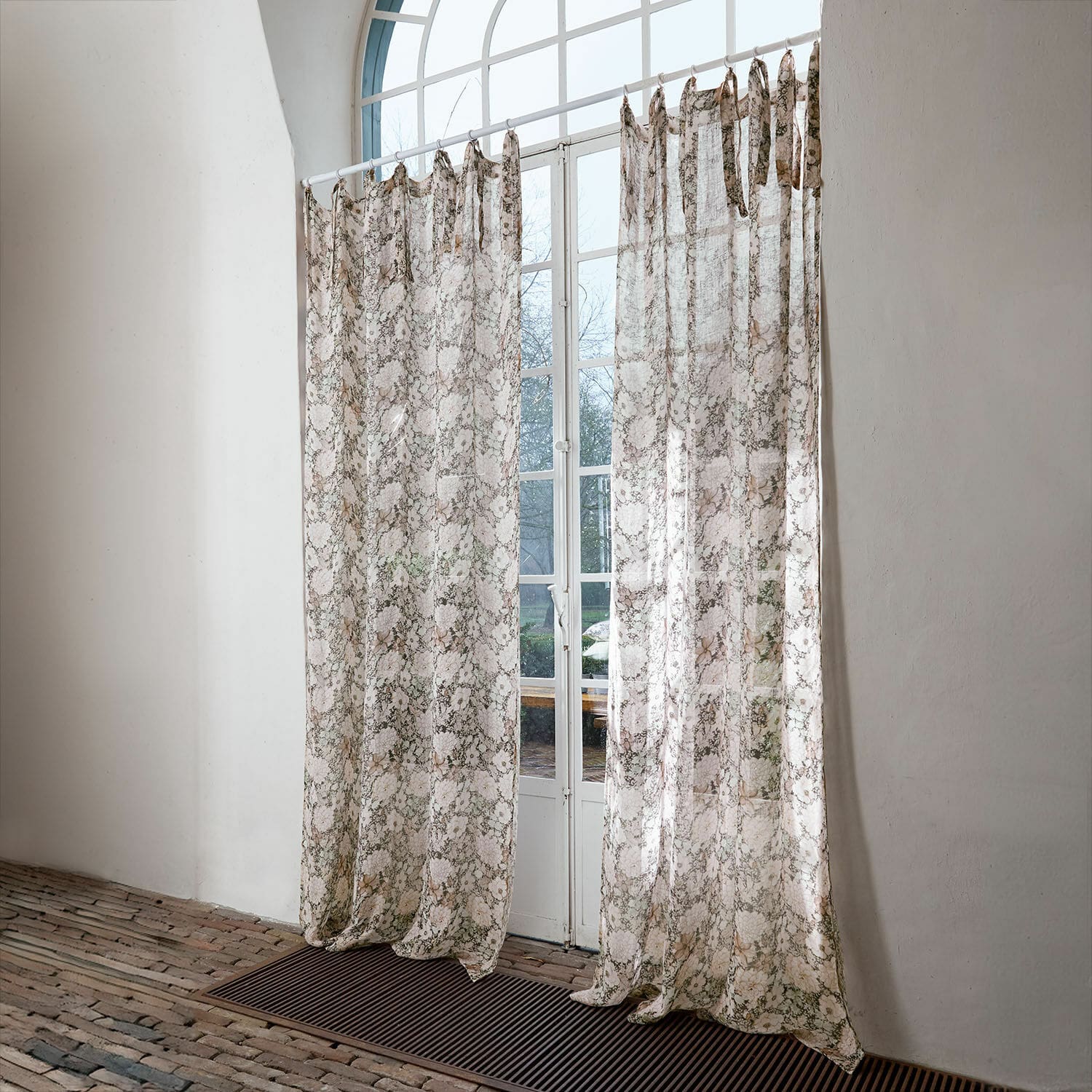 Gardine Cappellina Transparente Vorhänge mit zartem Muster in Beige- und Brauntönen vor weissem Fenster
