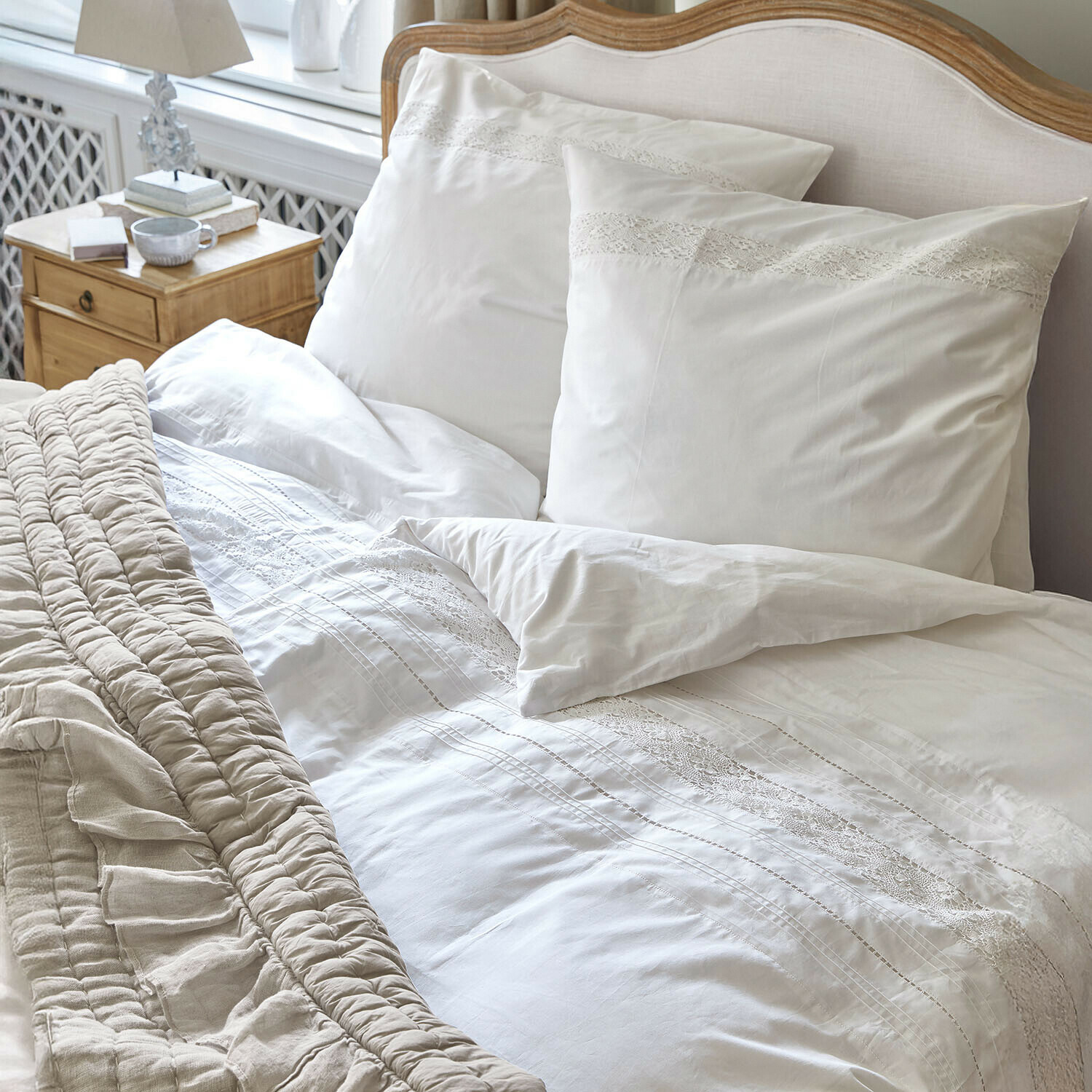 Bettwäsche Isolineas Weiße Bettwäsche mit Spitzenverzierung auf Holzbett mit beiger Decke