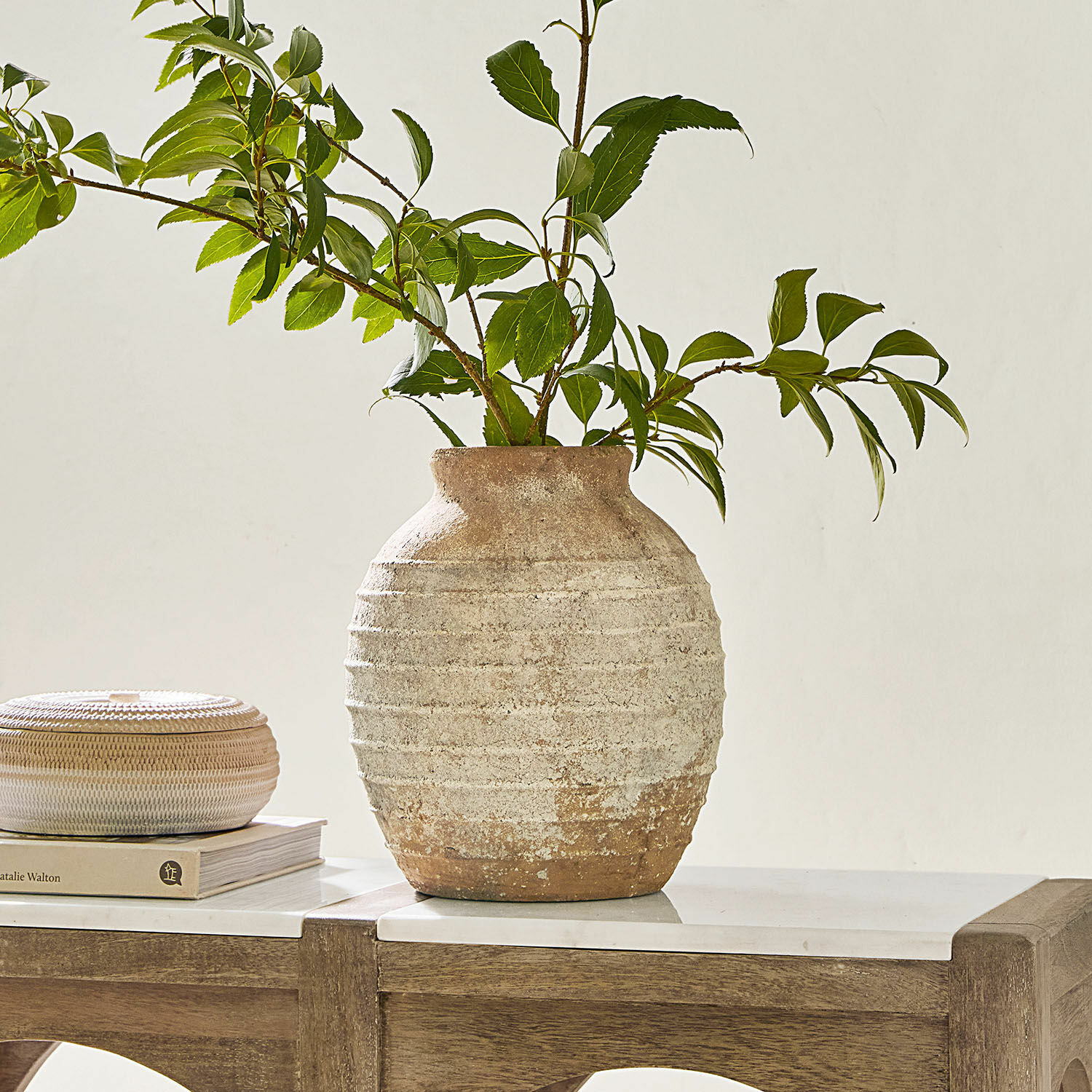 Vase Sibinna Rustikale Keramikvase in Beige-Braun mit grünen Zweigen auf einem Holztisch