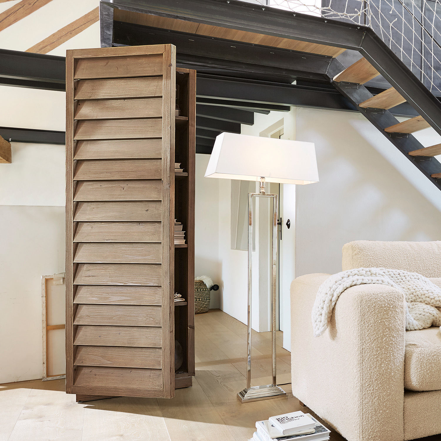 Schrank Bordó Holzschrank mit lamellenförmigen Türen in Naturfarbe im modernen Wohnzimmer mit Stehleuchte und Sofa