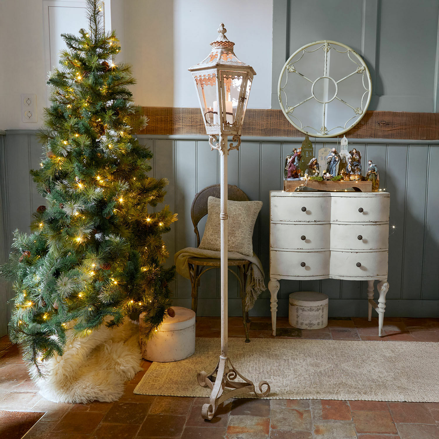 Laterne Lumière Élysée Weisse Metall-Stehlaterne mit dekorativem Muster in rustikalem Raum mit Weihnachtsbaum und Kommode
