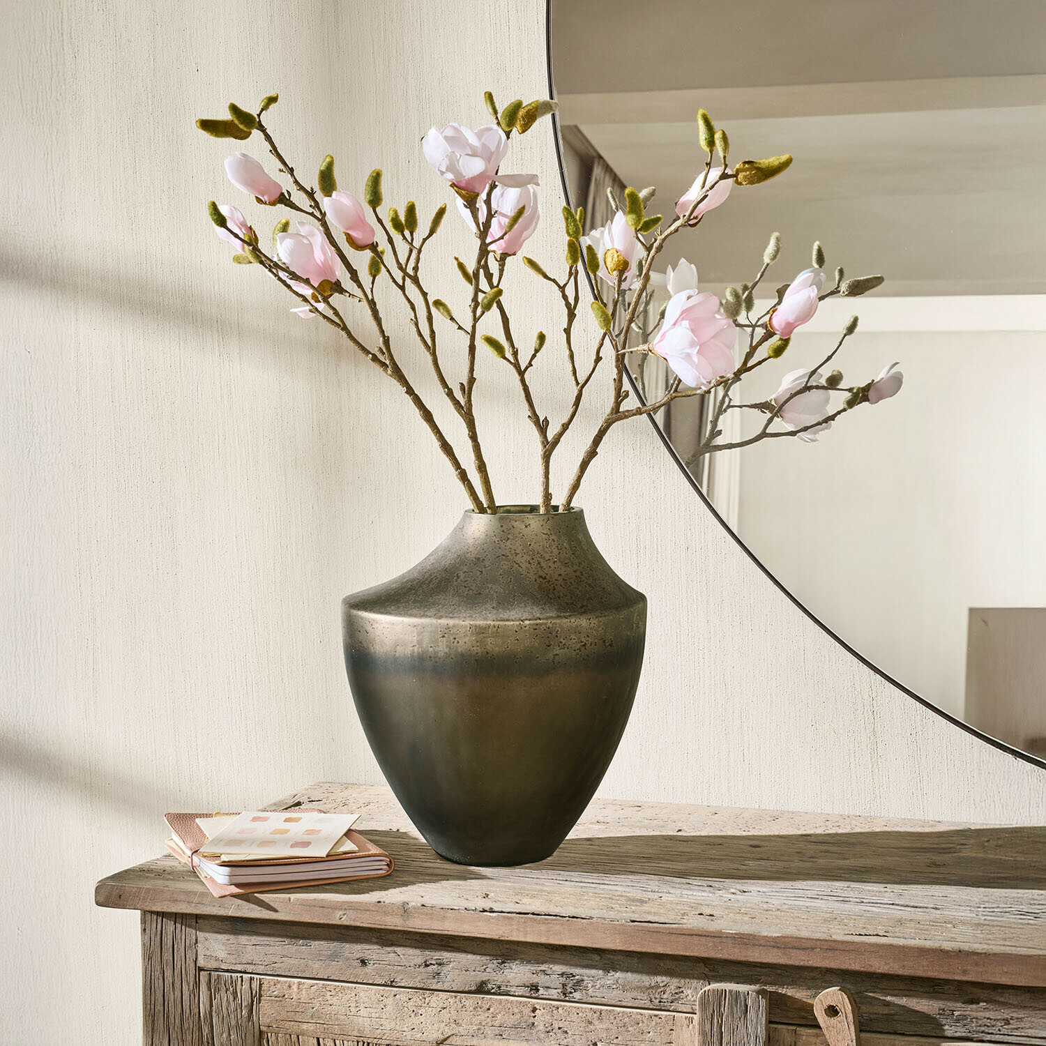 Vase Tavris Metallvase in dunklem Braun mit rosa Blütenzweigen auf rustikalem Holztisch