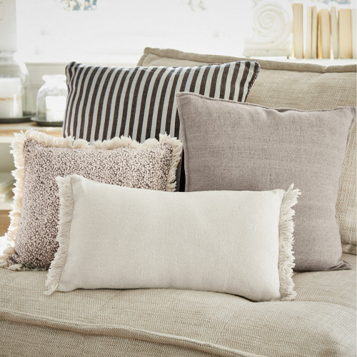 Set aus dekorativen Kissen in Beige- und Brauntönen auf beigem Sofa, weiche Materialien, Wohnzimmerdekoration