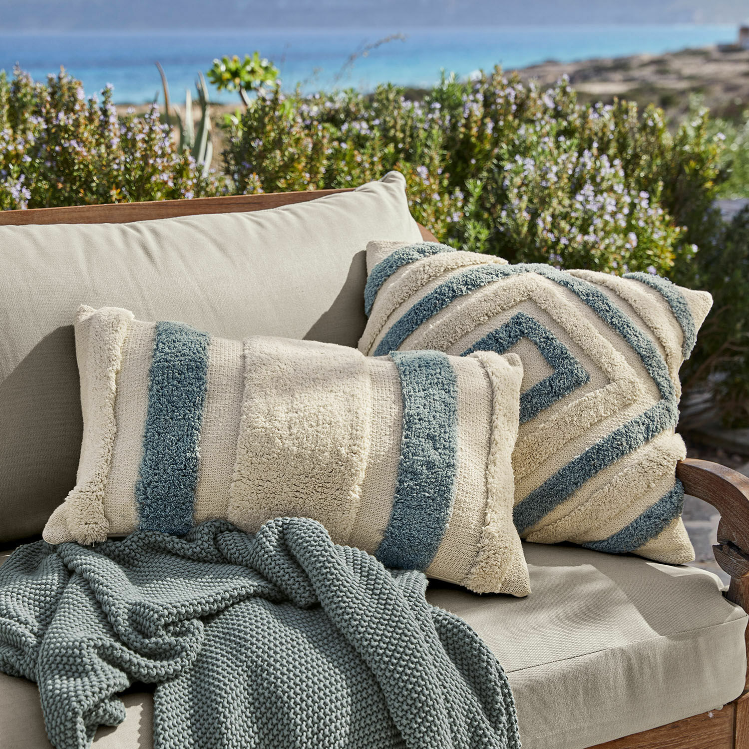 Kissenhülle 2er Set Melyn Beige-blaue dekorative Kissen aus weichem Material auf beigem Sofa mit gestrickter Decke