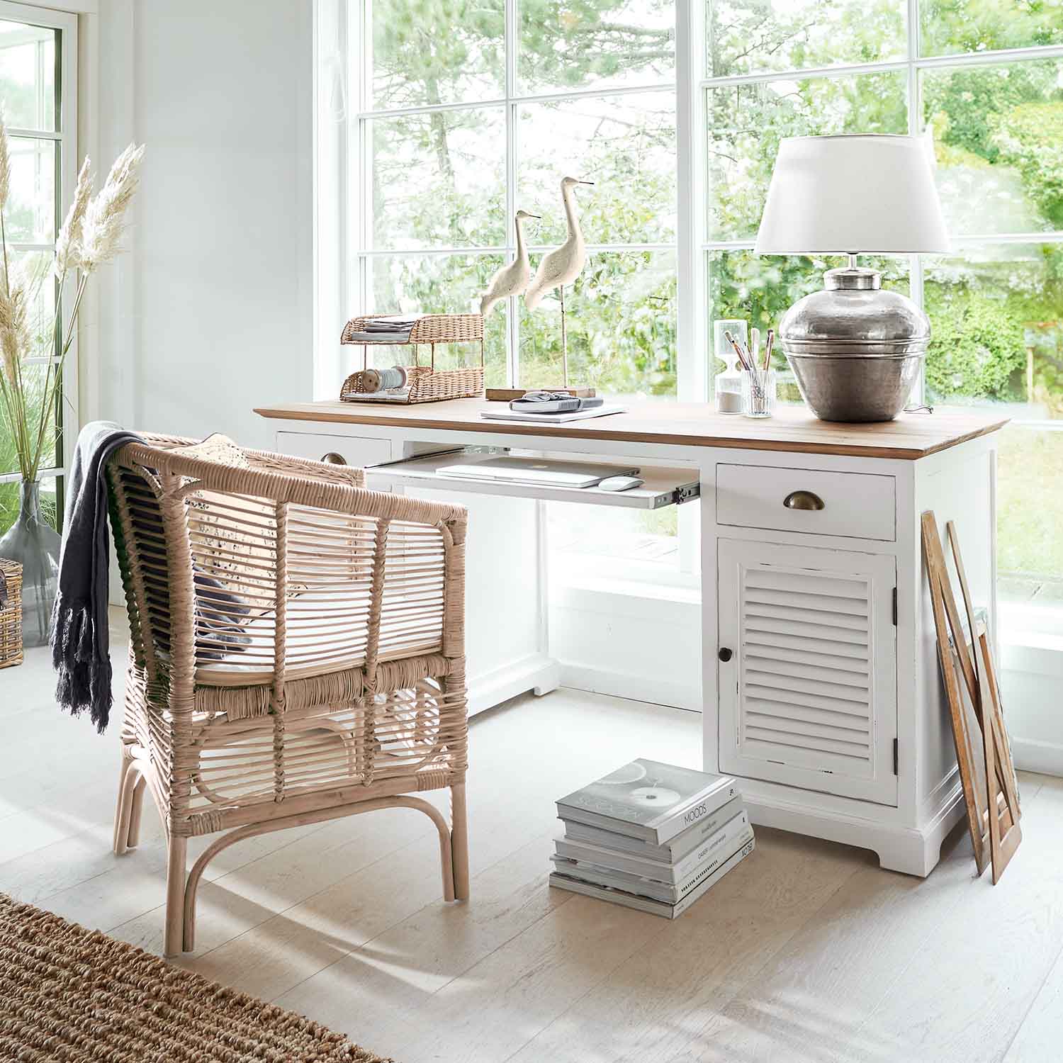 Weißer Holzschreibtisch mit natürlicher Tischplatte und Rattanstuhl in hellem Raum mit großem Fenster