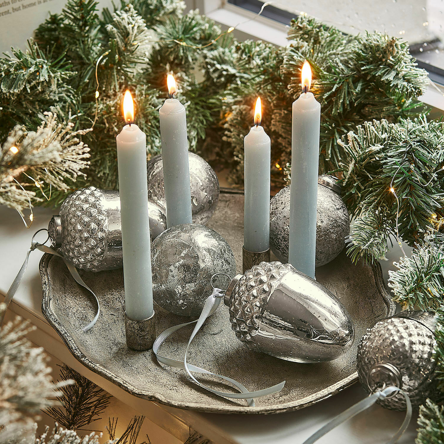 Kerzen-Tablett Noirelle Metalltablett mit vier weissen Kerzen und silbernen Weihnachtskugeln, umgeben von grünen Tannenzweigen